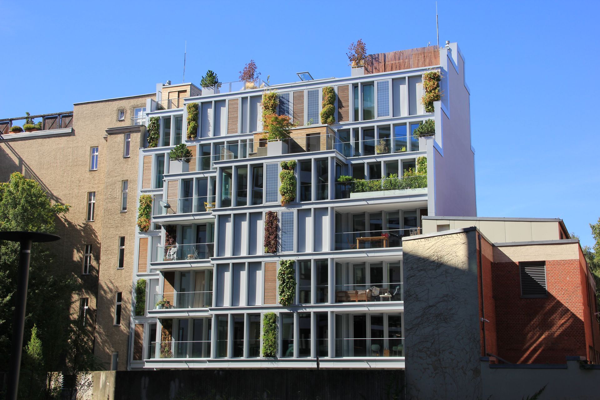Ein Gebäude mit vielen Fenstern und Pflanzen auf dem Dach