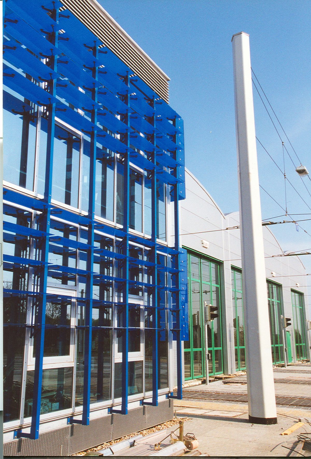 Ein blaues Gebäude mit einem weißen Mast davor