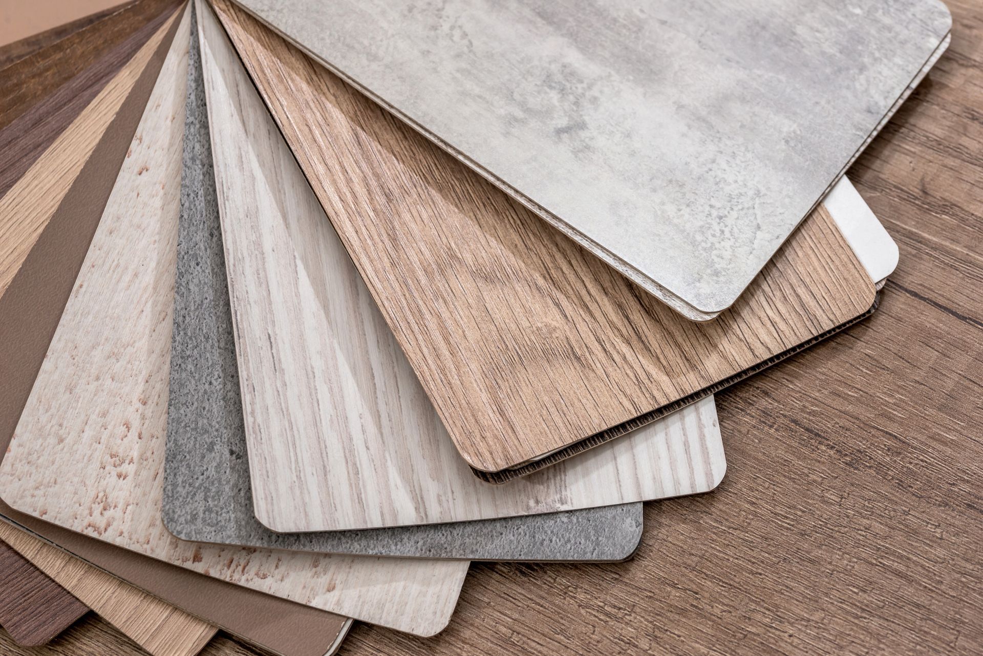 A bunch of different types of wood samples are stacked on top of each other on a wooden table.