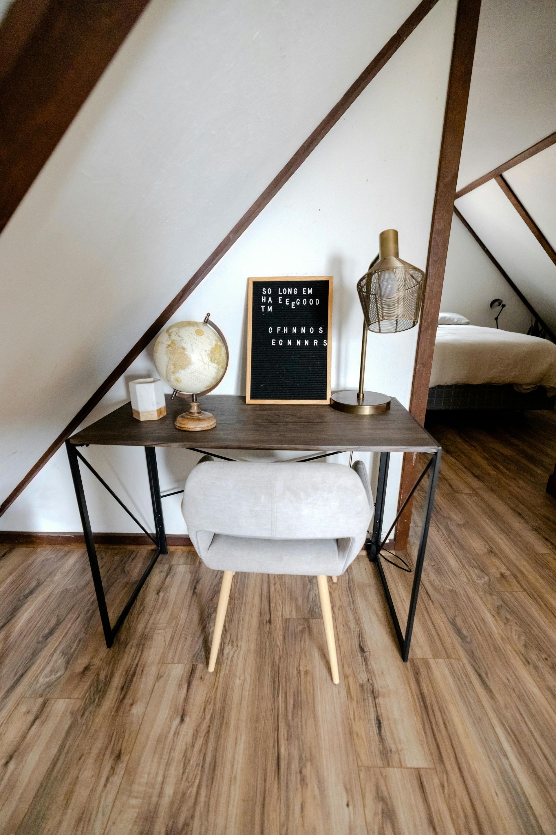 There is a desk with a chair and a globe on it.