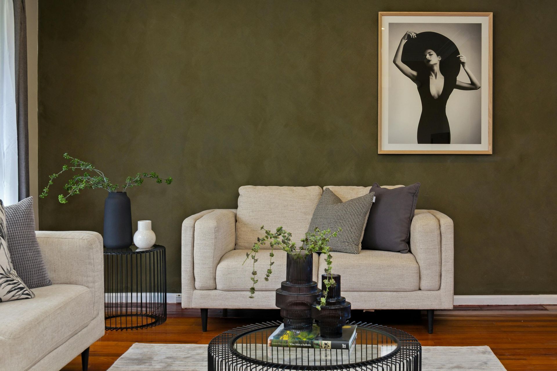 A living room with a couch , chair , coffee table and a picture on the wall.