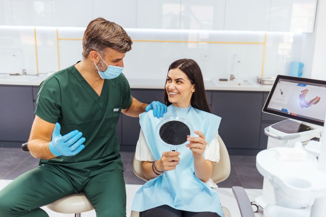 Dentist consultation showing digital smile design with mirror review