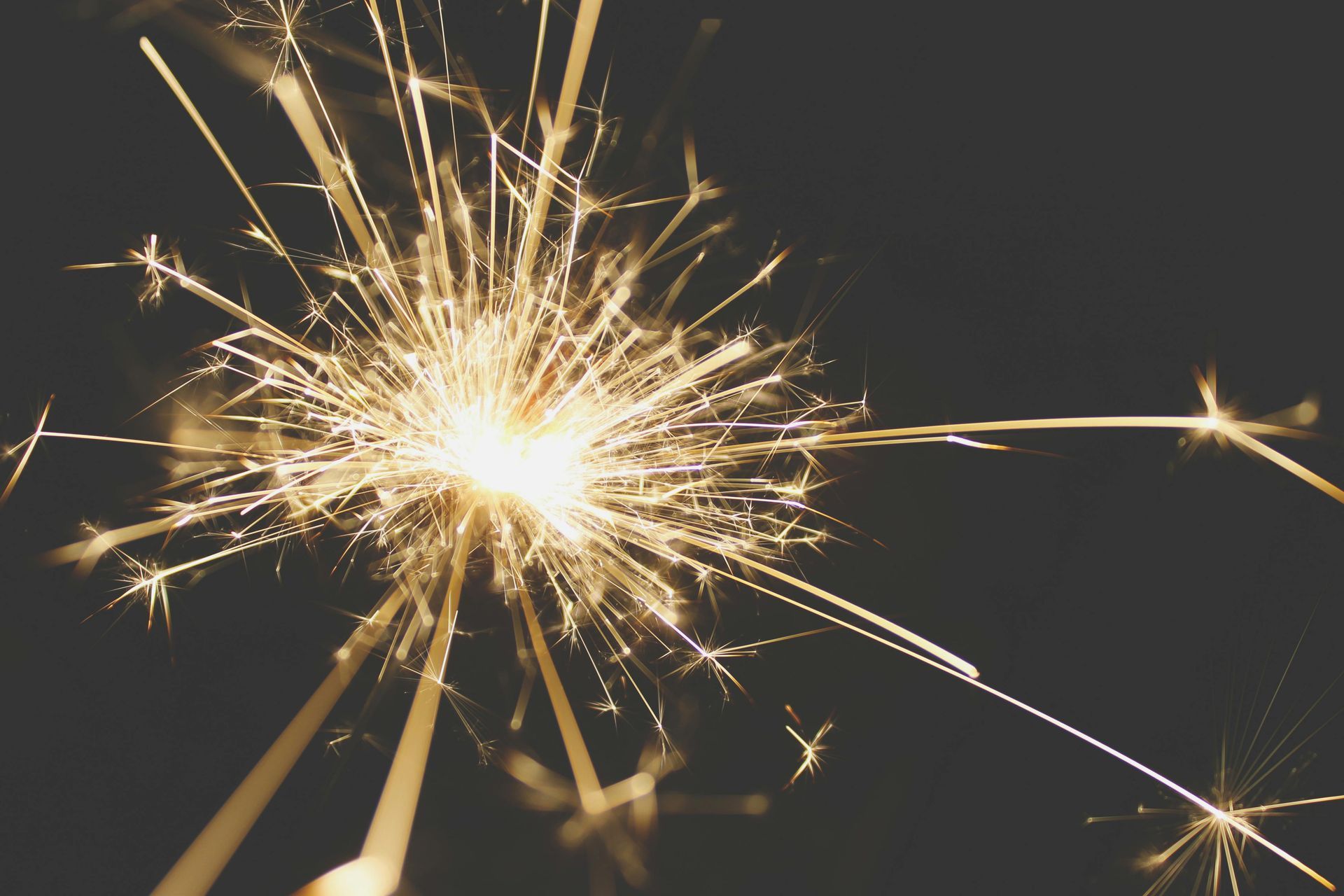 Sparkler sparks against dark background.