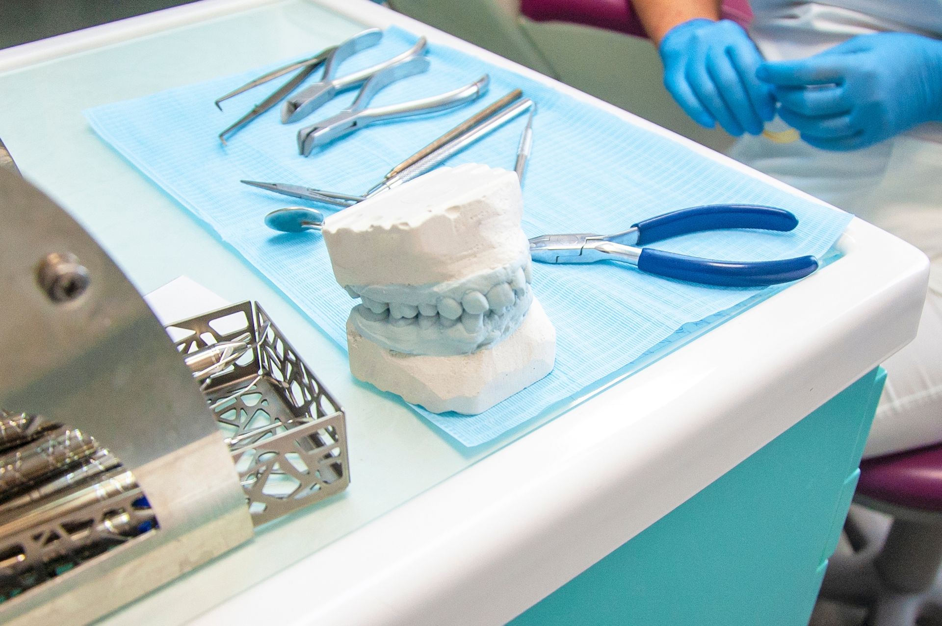 Dental tools and a mold of teeth on a tray in a dental office.