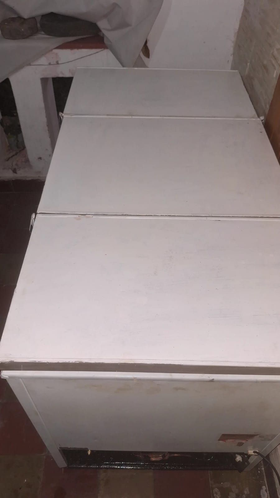 Armario o cómoda de madera blanca con tapa de panel, visto desde arriba en una habitación.