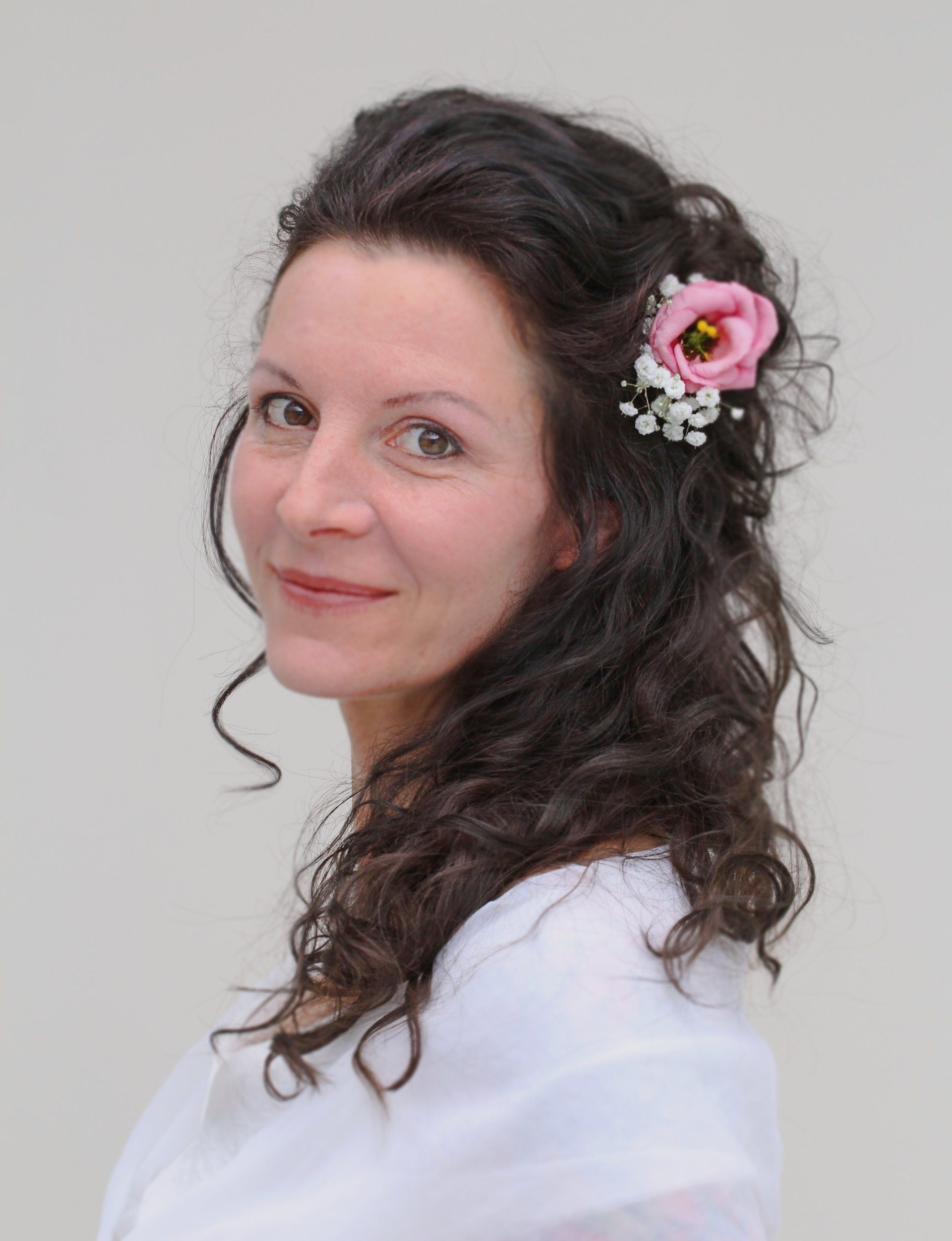 Eine Frau mit einer rosa Blume im Haar