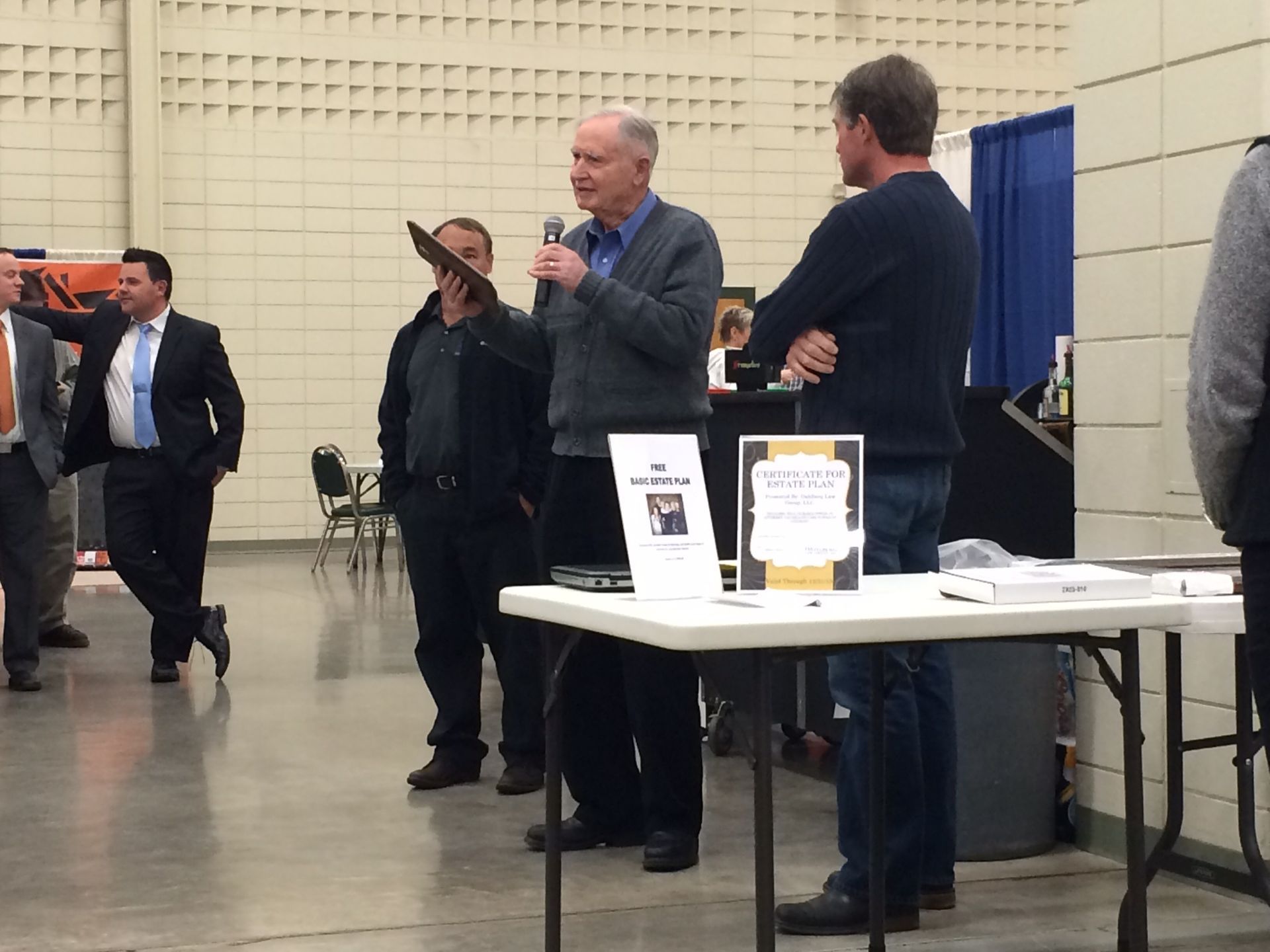 A group of men are standing around a table with a sign that says thank you