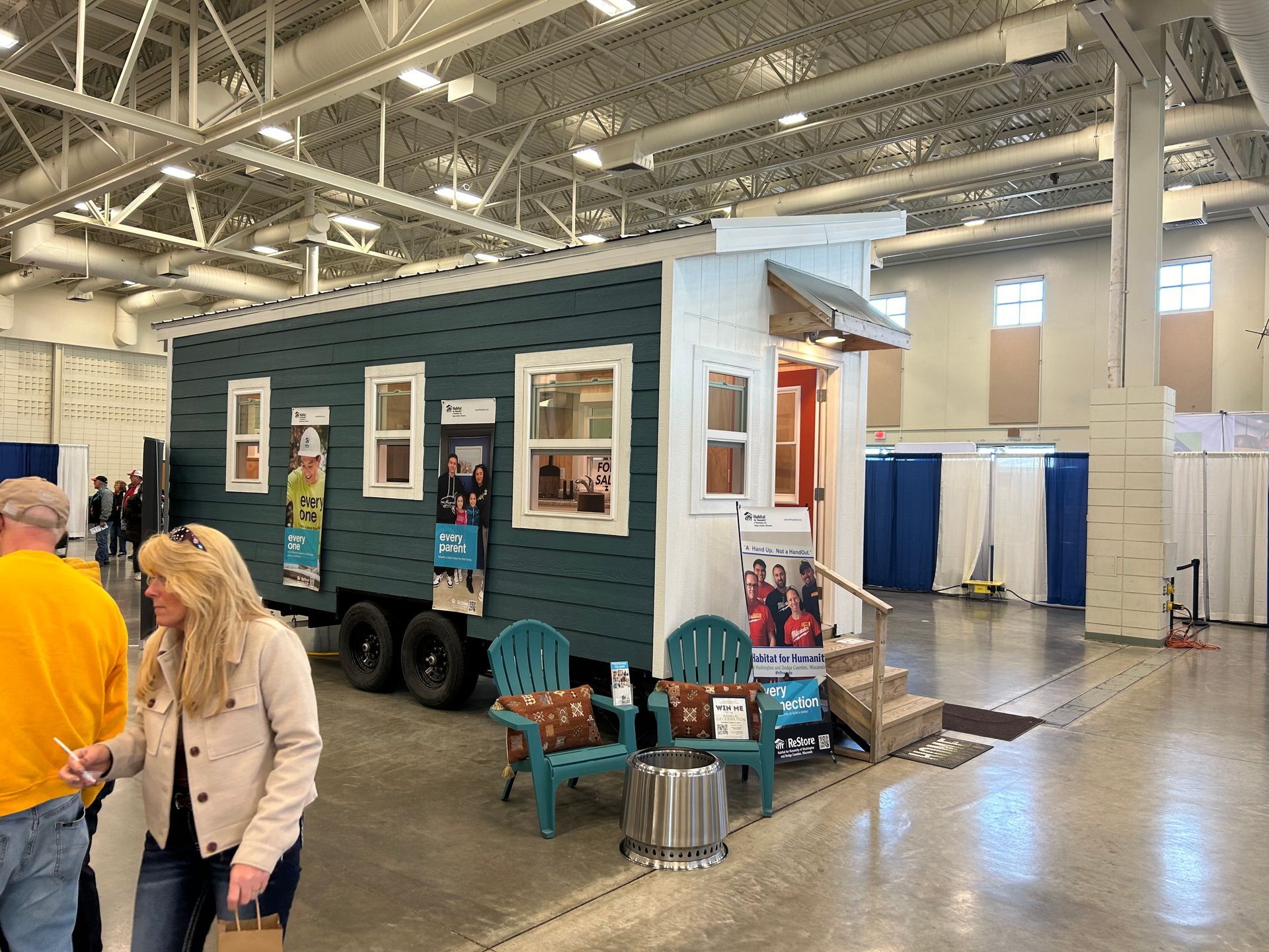 A tiny house on wheels is on display at a convention.