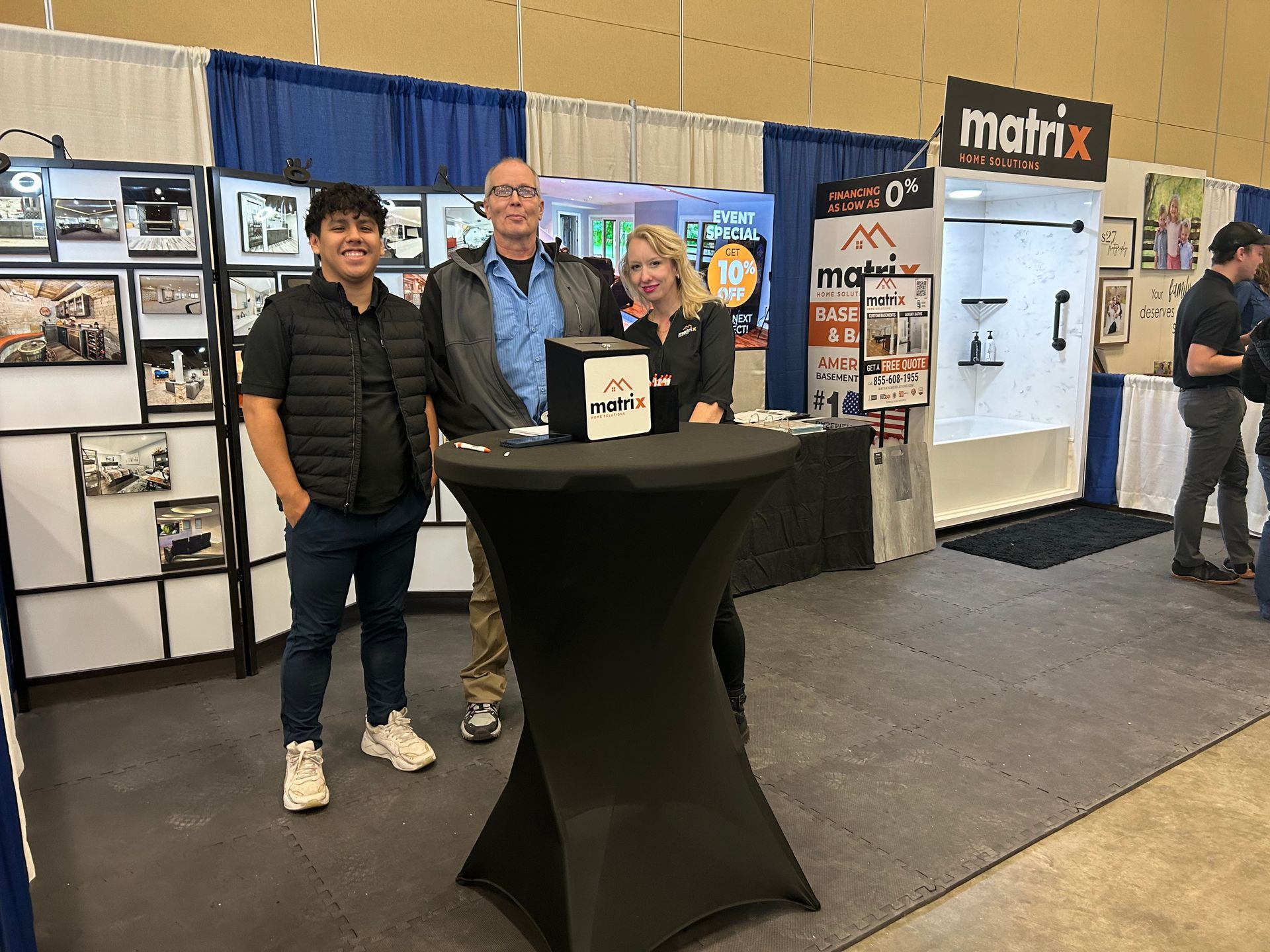 A group of people are standing around a table at a convention.