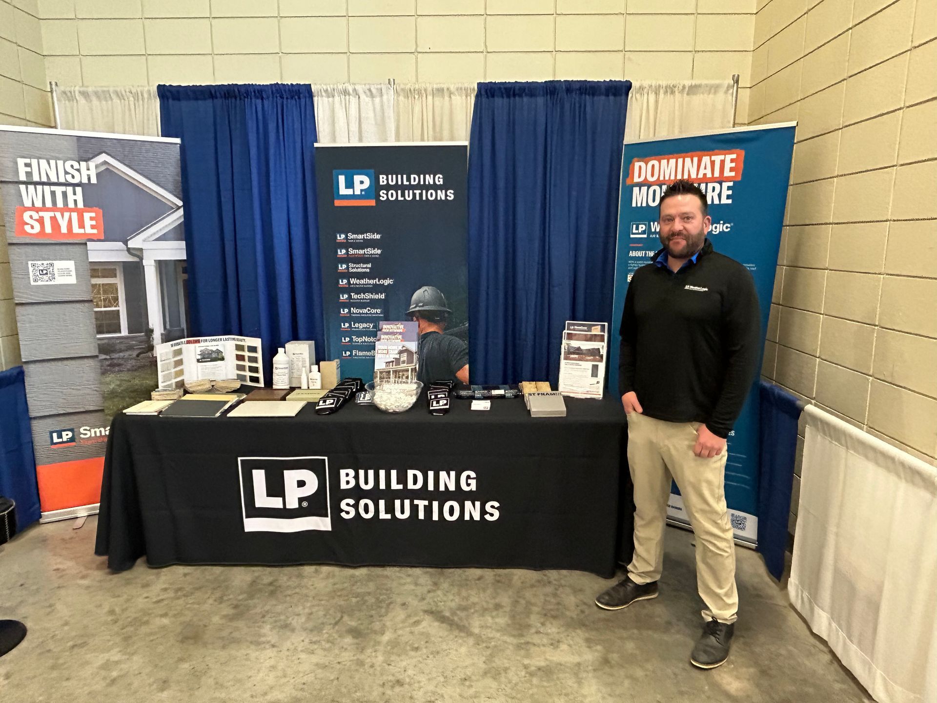 A man is standing in front of a building solutions table.