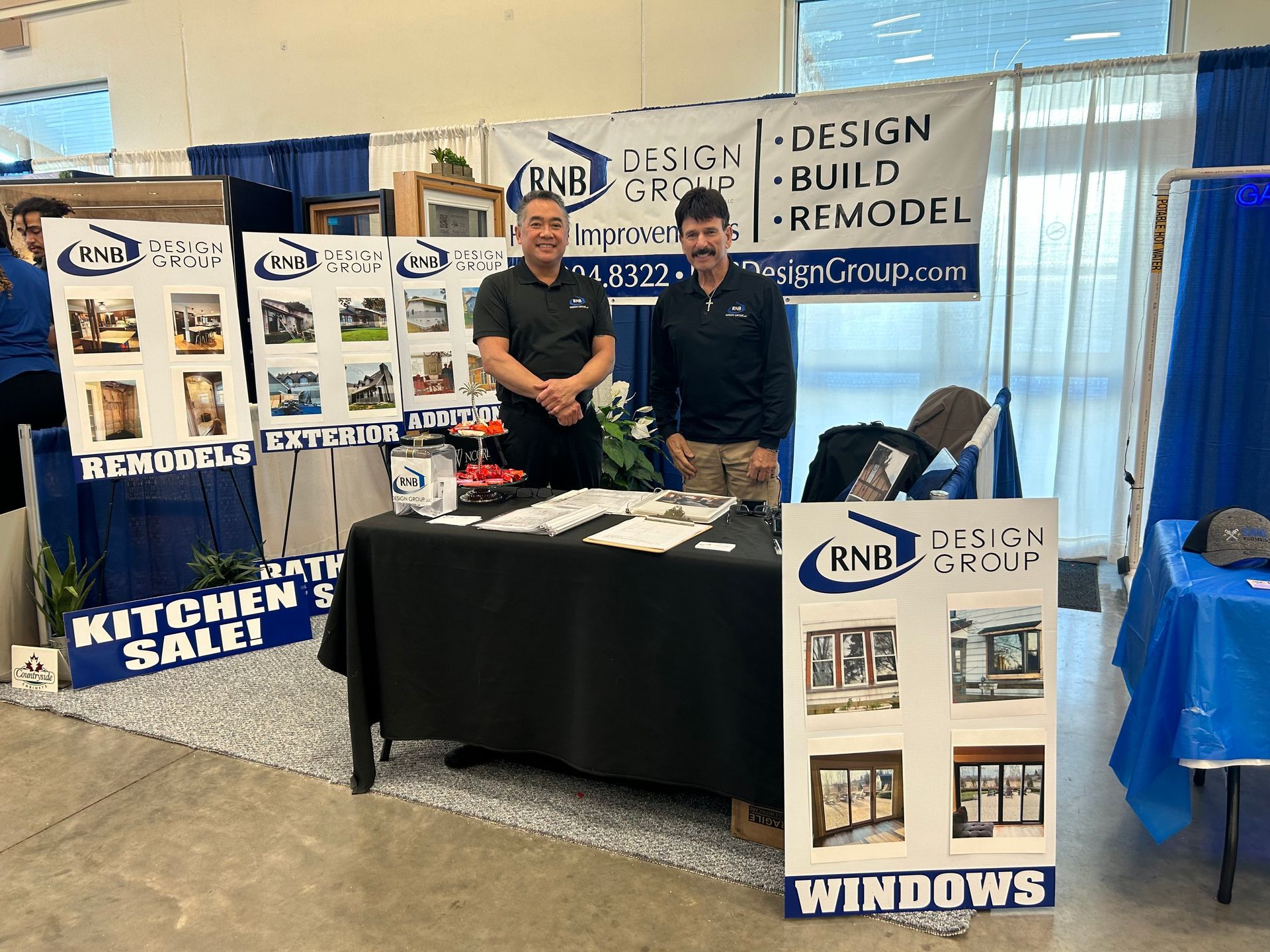 Two men are standing in front of a table at a window showroom.