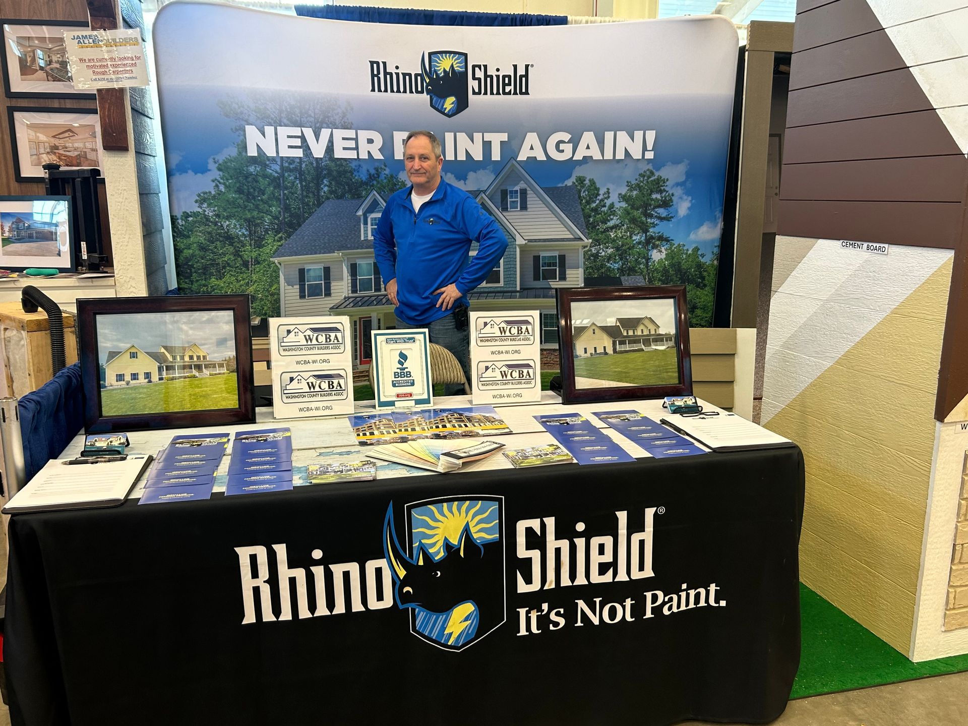 A man is standing in front of a rhino shield table