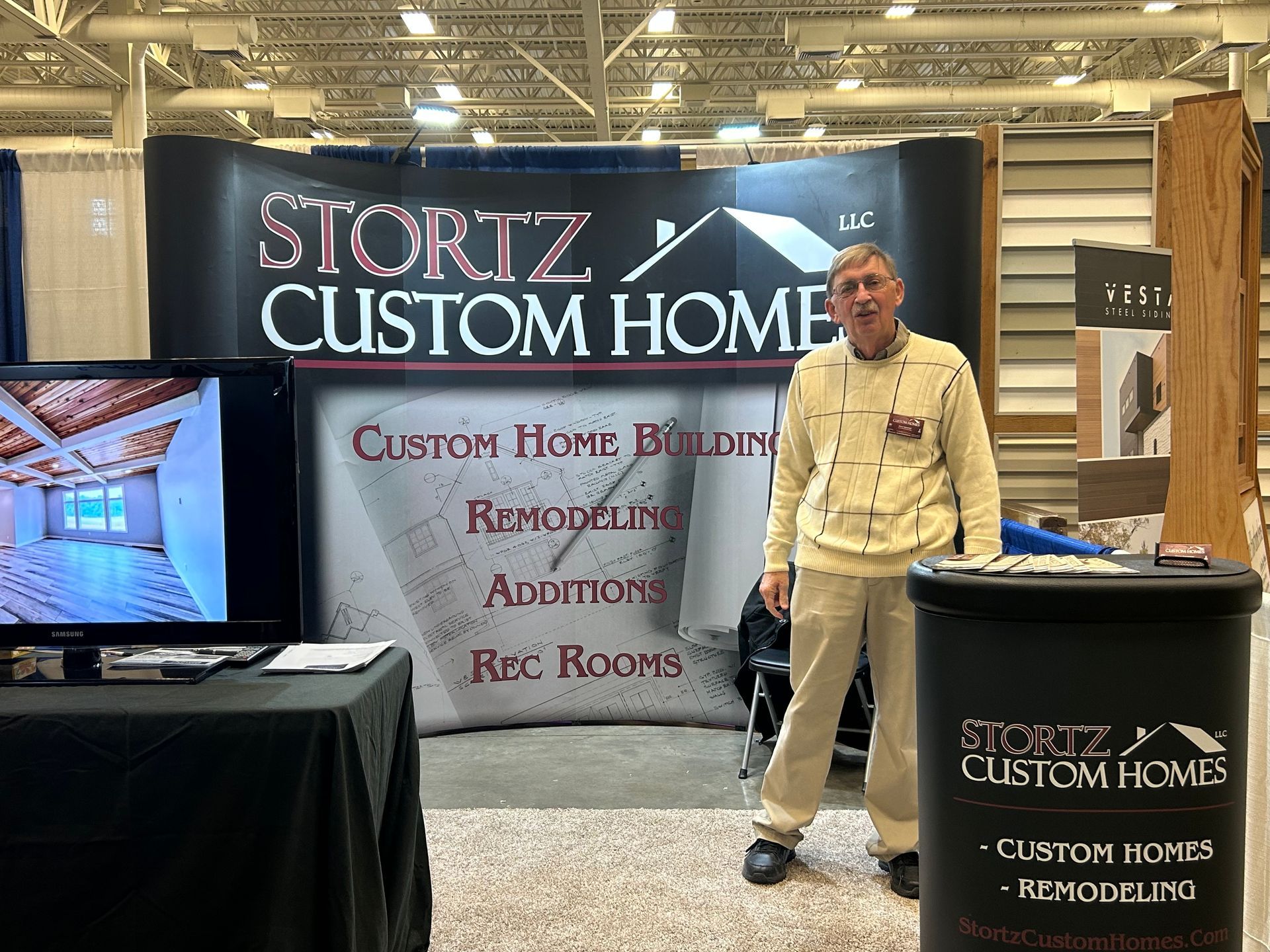 A man is standing in front of a stortz custom home sign