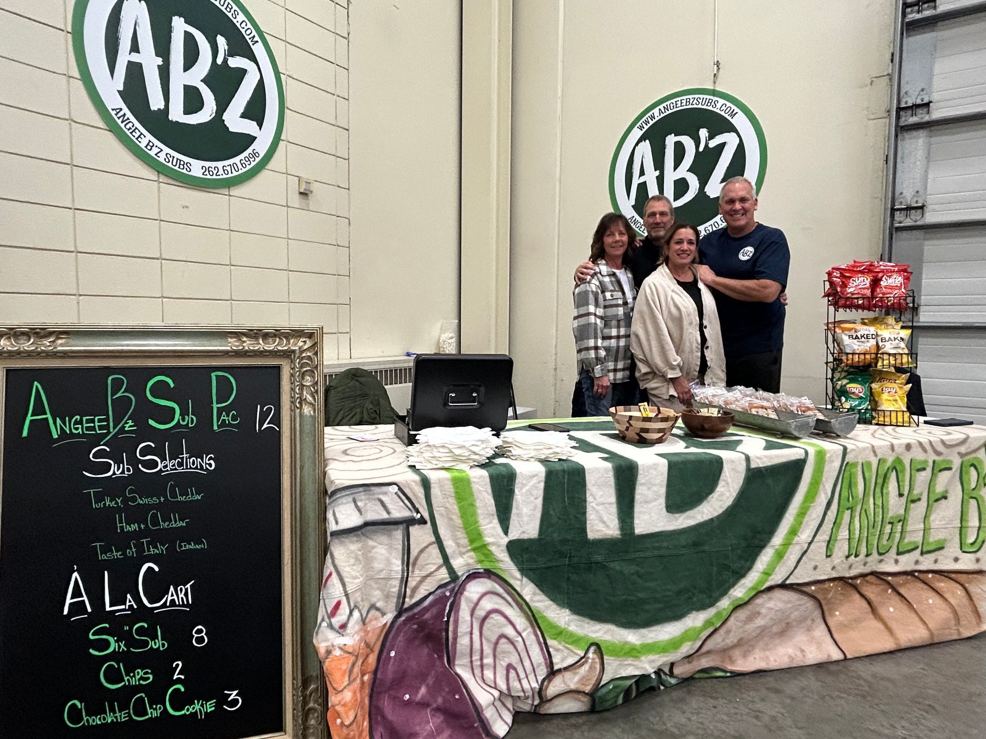 A group of people standing around a table with a sign that says abz
