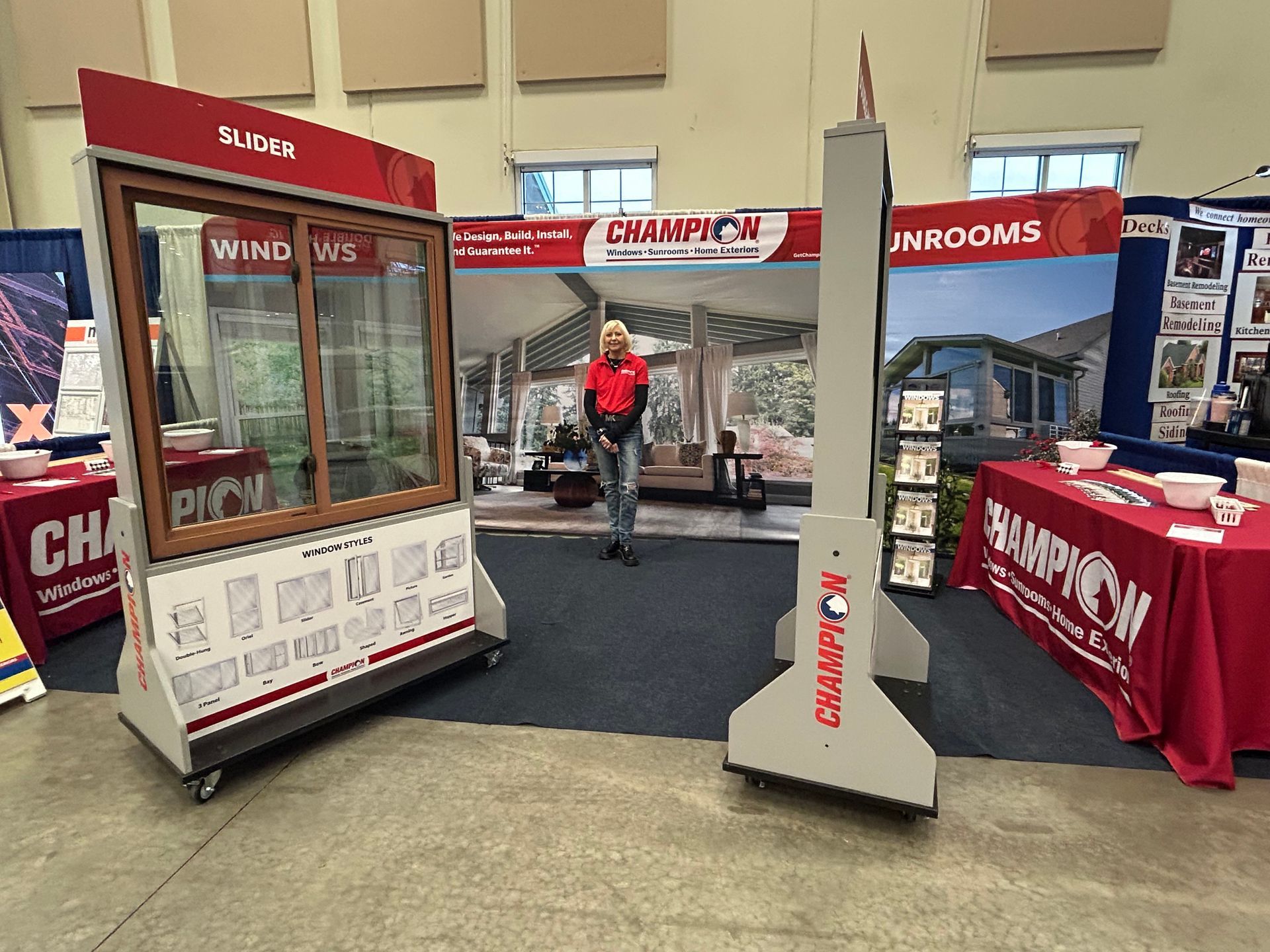 A man is standing in front of a window display at a trade show.