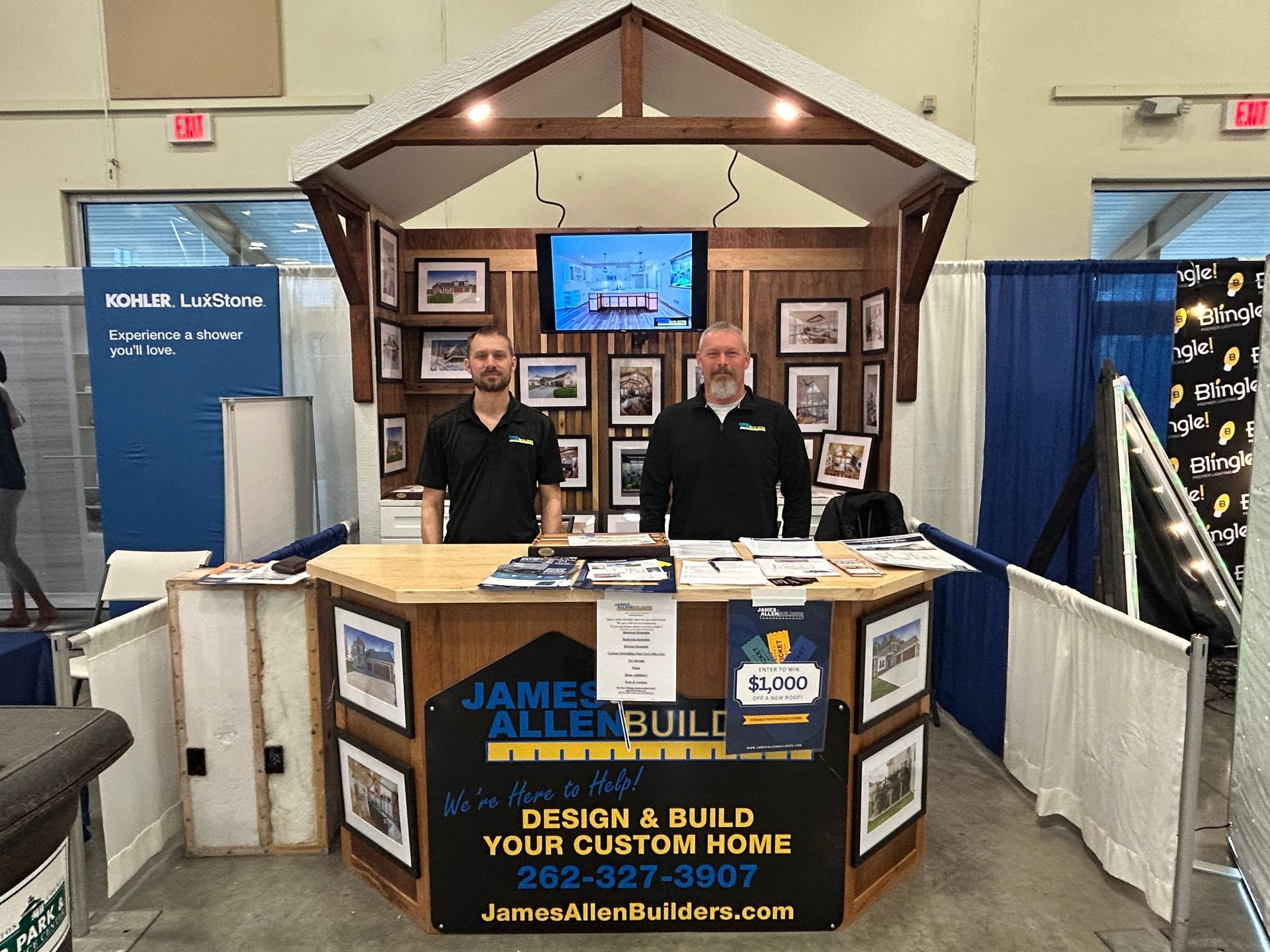 Two men are standing behind a counter with a sign that says design and build your custom home.