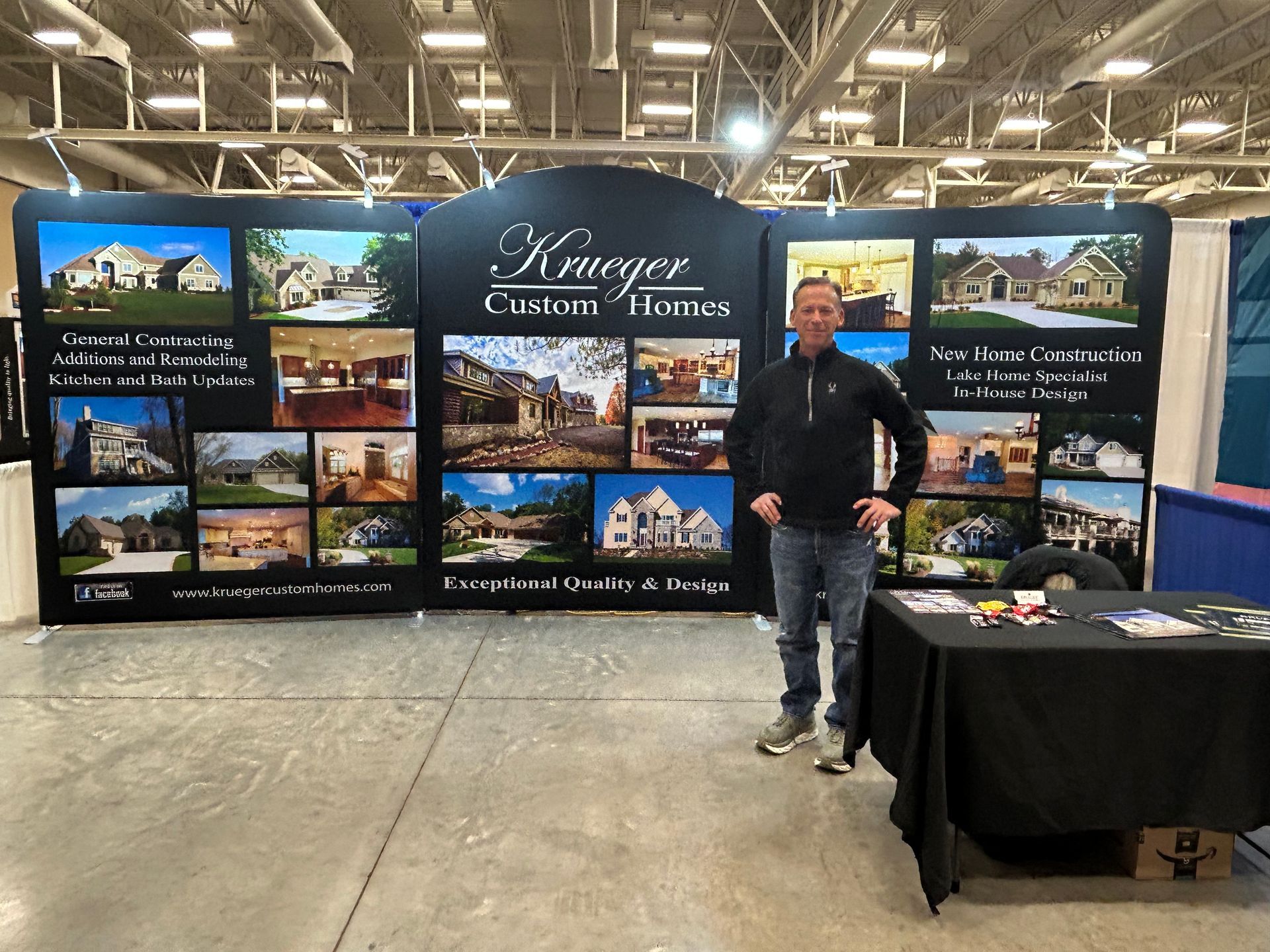 A man stands in front of a wall that says kaweger custom homes