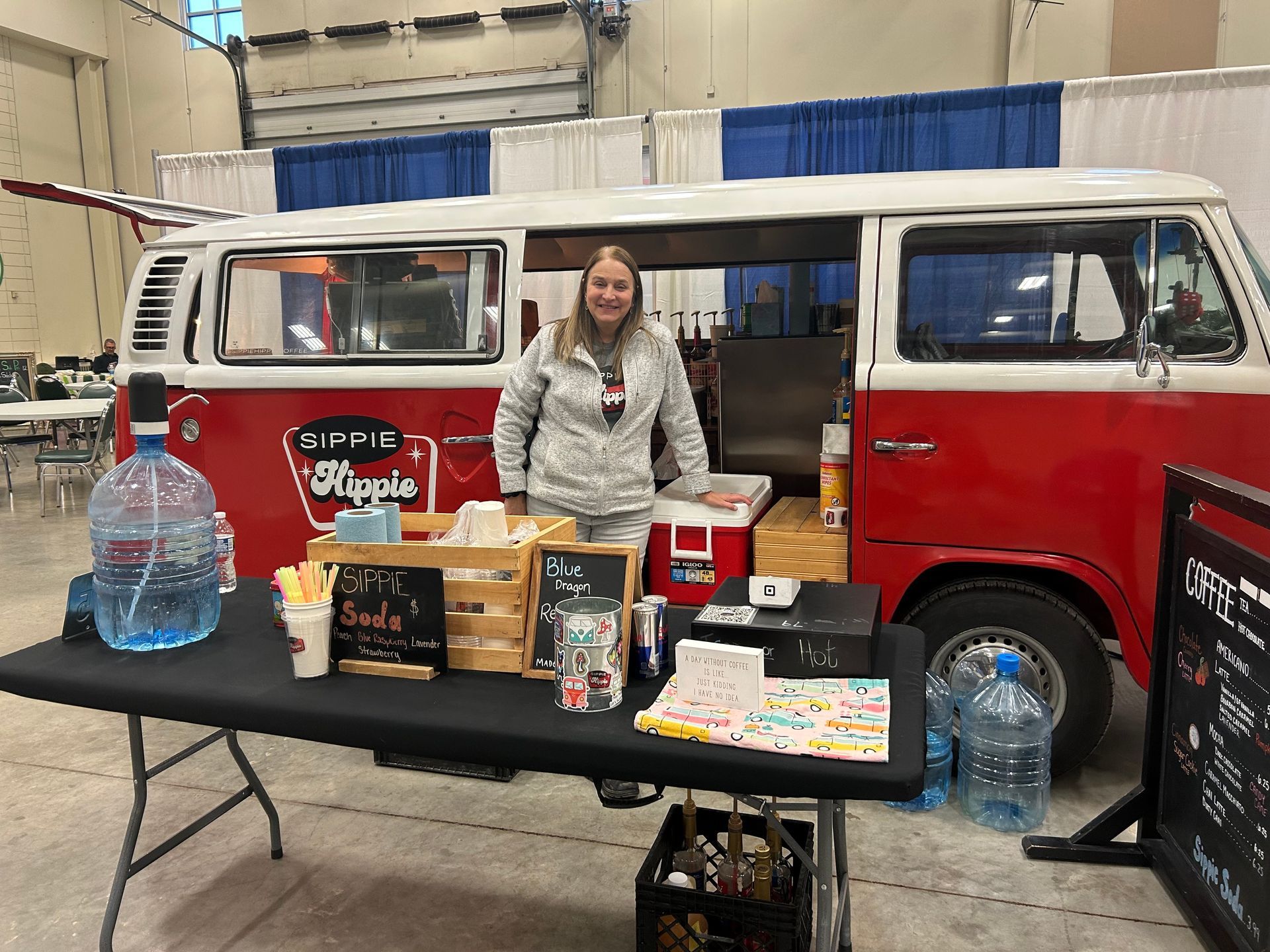 A woman is standing in front of a red van.