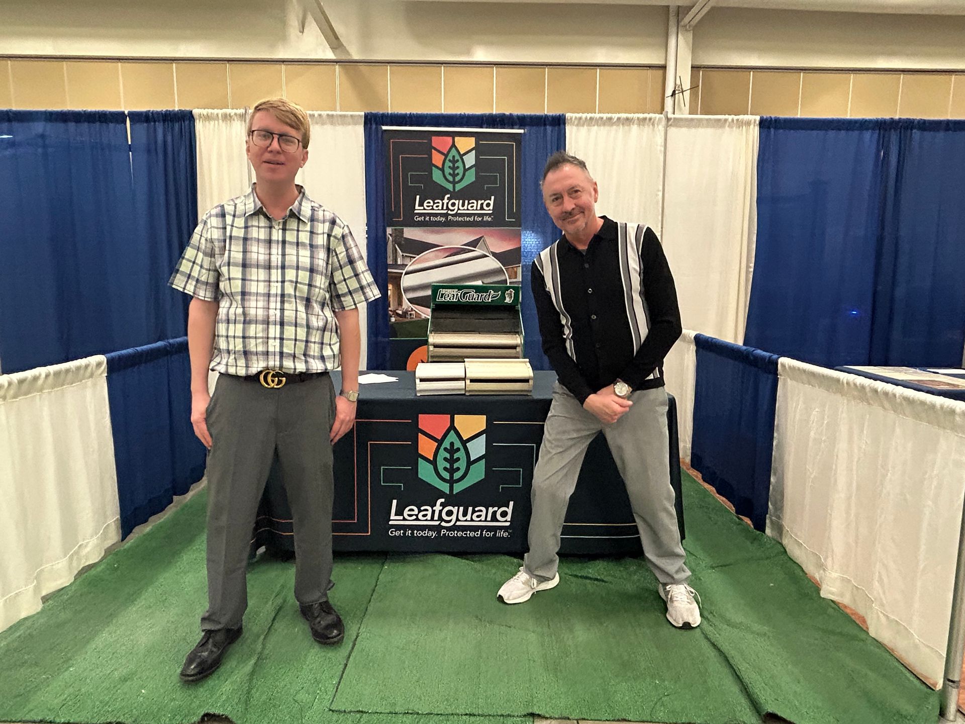 Two men are standing in front of a leafguard booth.