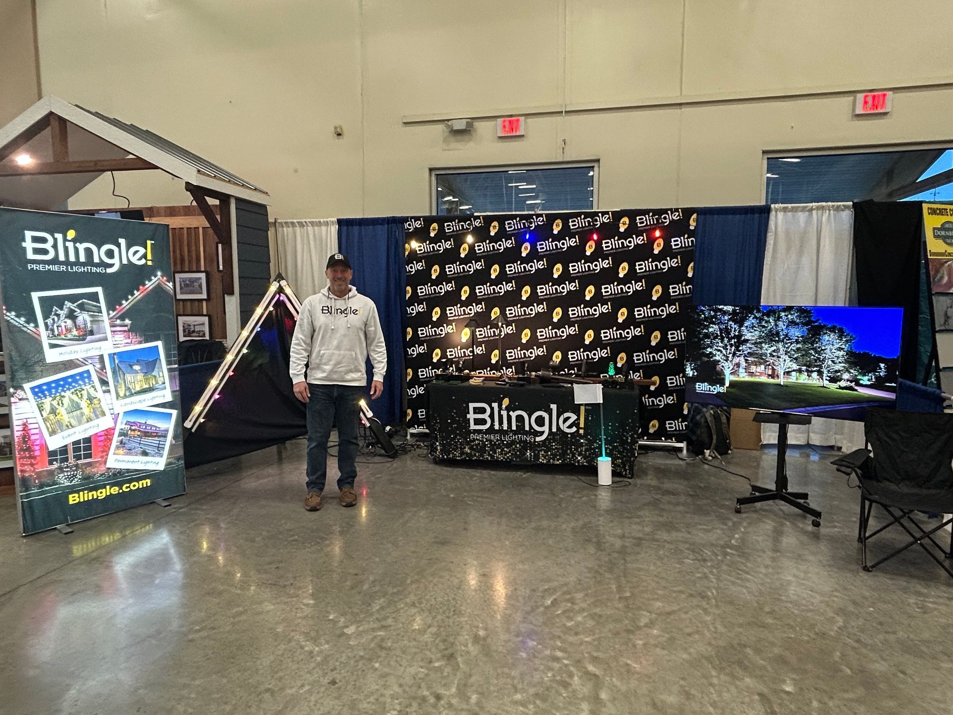 A man is standing in front of a table with a sign that says blingle.