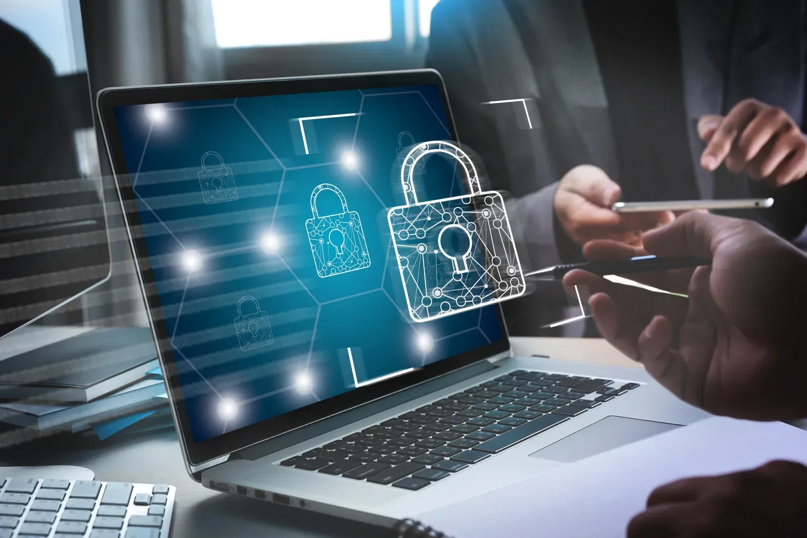 Laptop with cybersecurity lock icons on screen during a business meeting