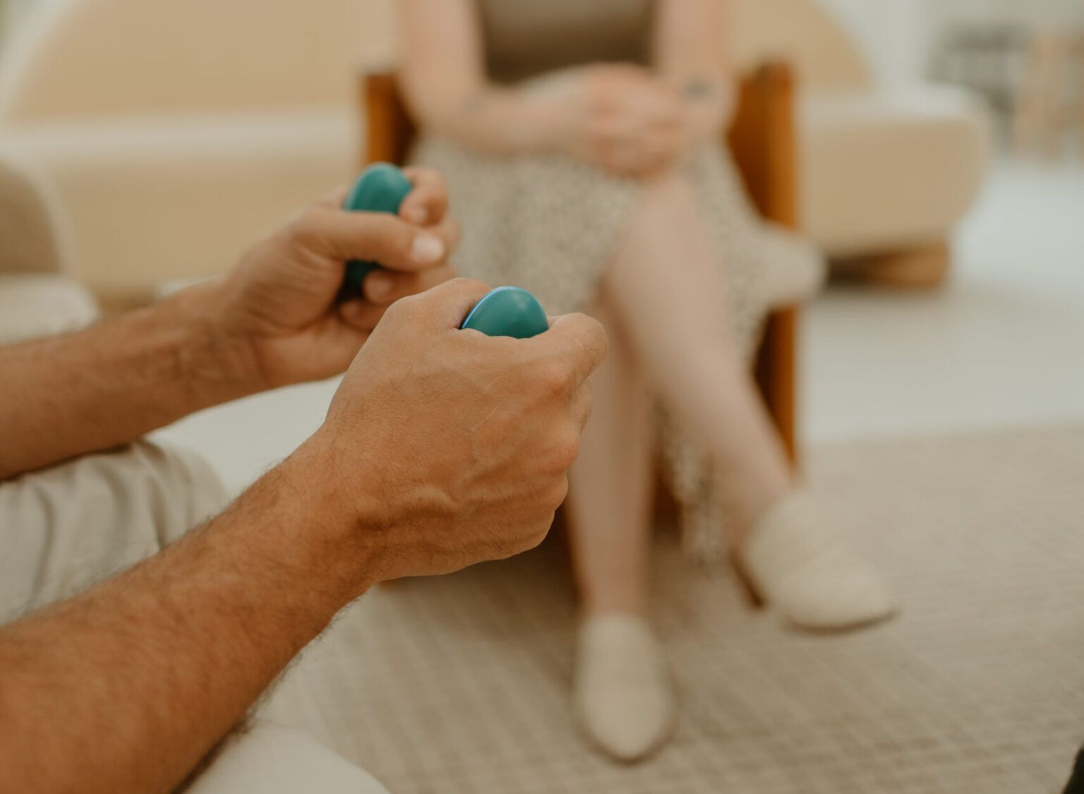 Person holding EMDR bilateral stimulation buzzers during a ketamine-assisted EMDR therapy session