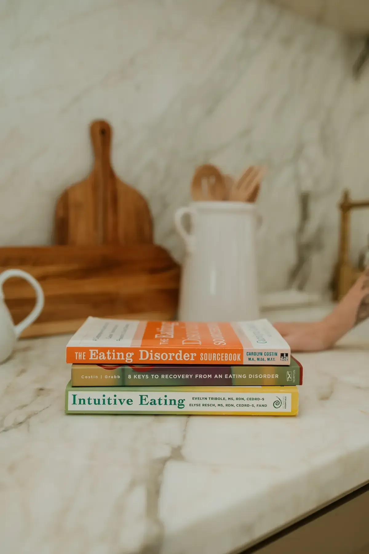 Stack of therapy and recovery books on a kitchen counter