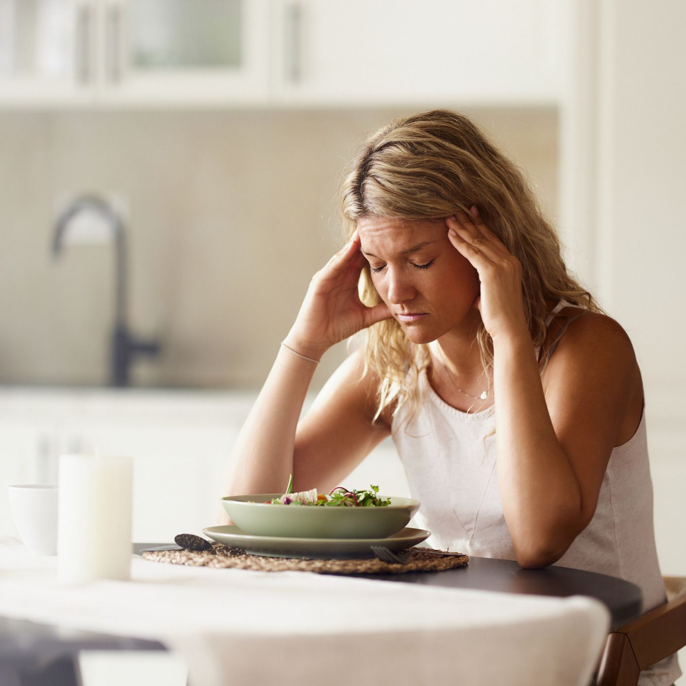 Woman with anorexia struggling to eat her meal.