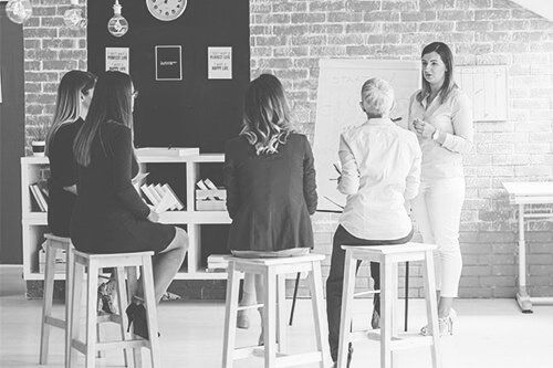 Black and white photo of business women listening to a presenter
