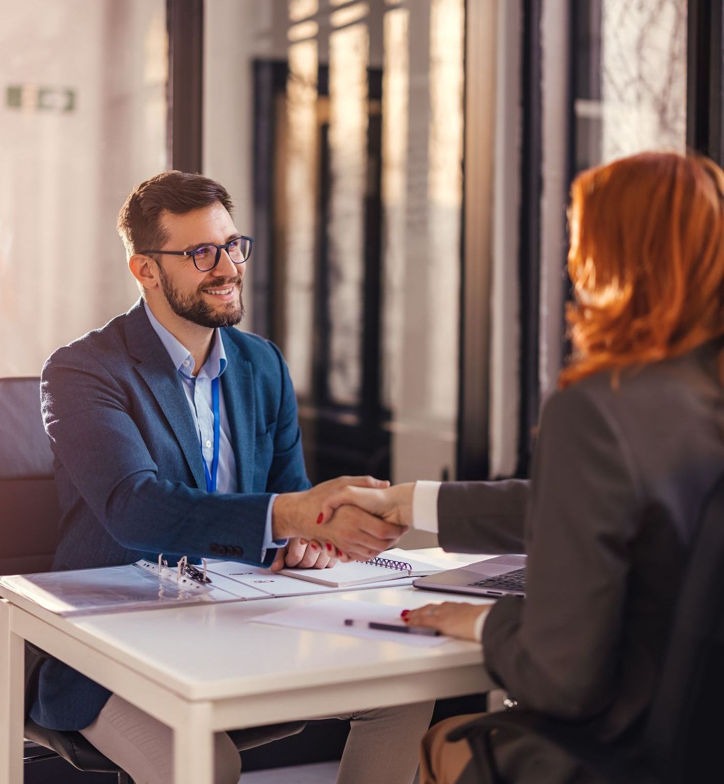 A businessman and a businesswoman shaking hands