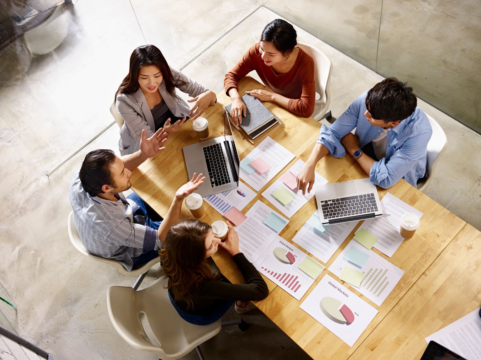 Overhead view of marketing team working together looking over charts