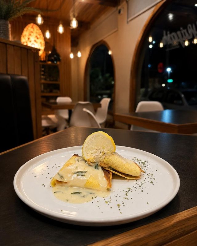 Postre emplatado con helado sobre una mesa de restaurante junto a una ventana por la noche.