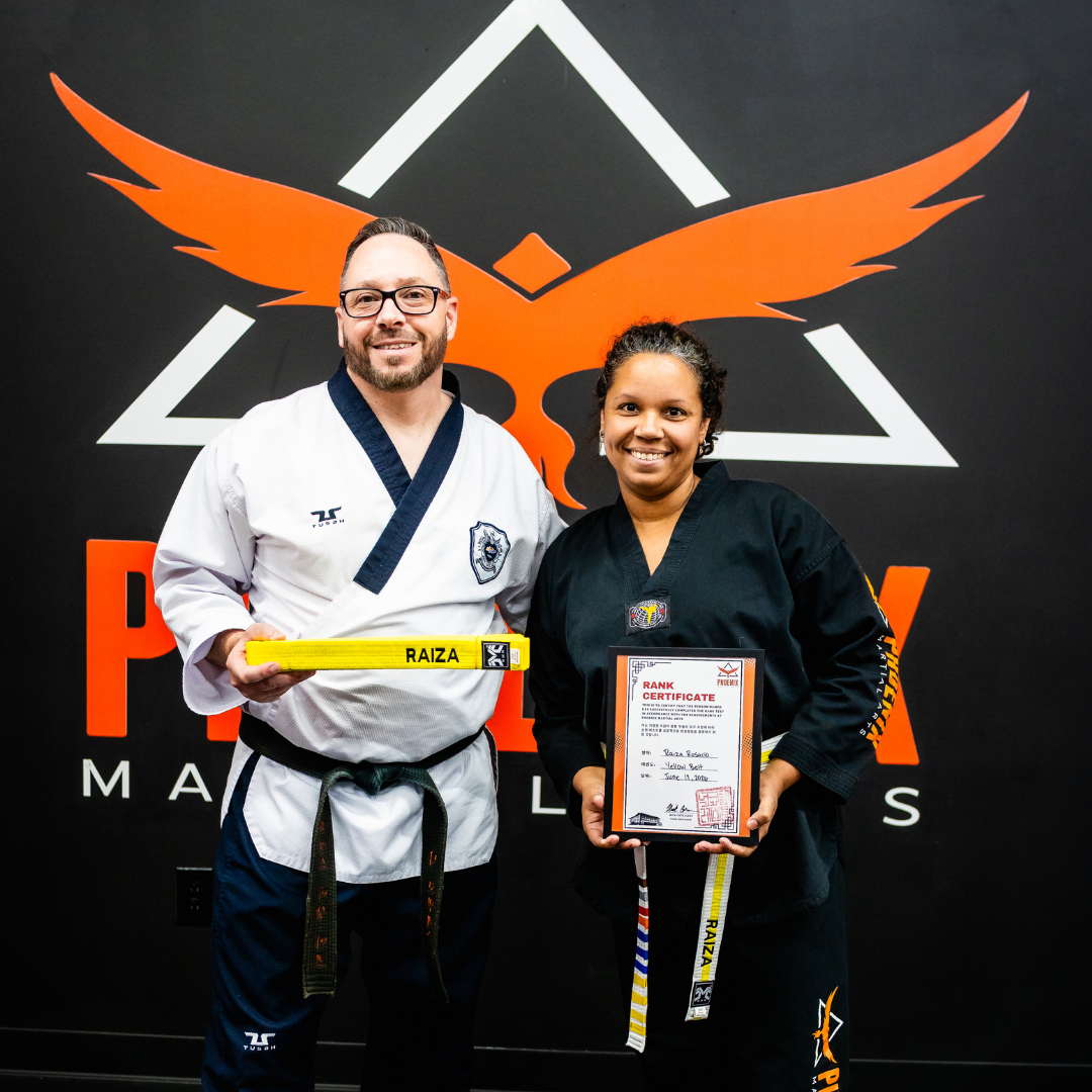 Adult martial arts student receiving a belt promotion certificate at Phoenix Martial Arts in Murfreesboro, TN