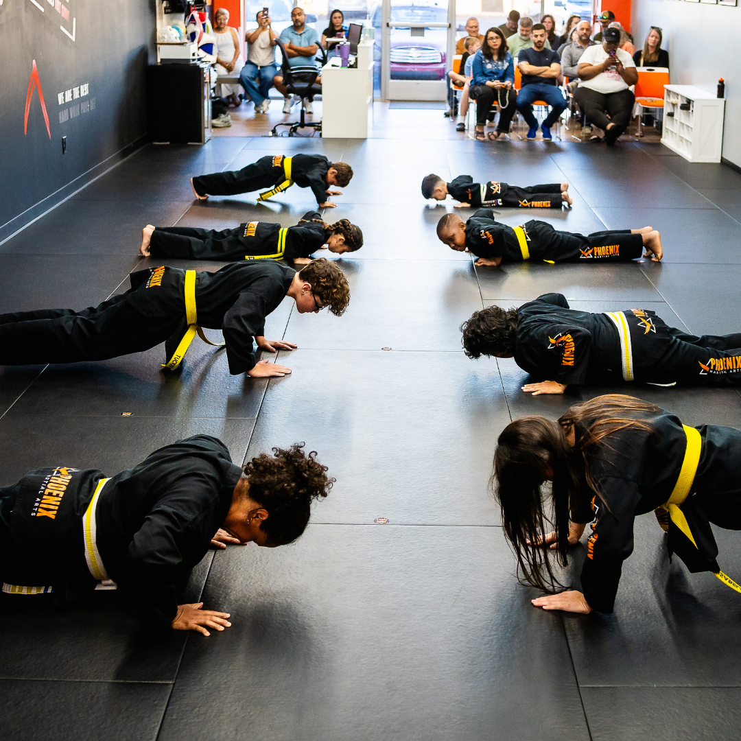 Adult martial arts students completing push-ups during fitness training at Phoenix Martial Arts in Murfreesboro, TN
