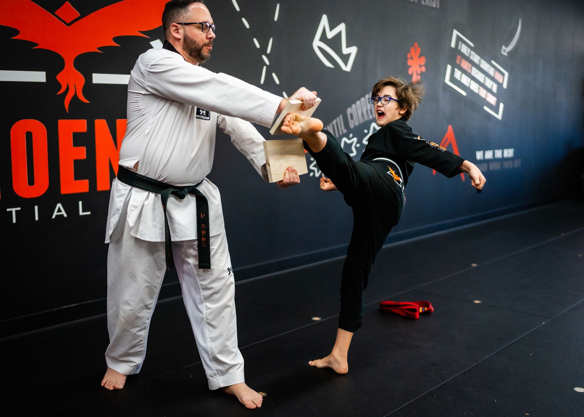 Teen student breaking a board to build confidence and perseverance at Phoenix Martial Arts in Murfreesboro, TN