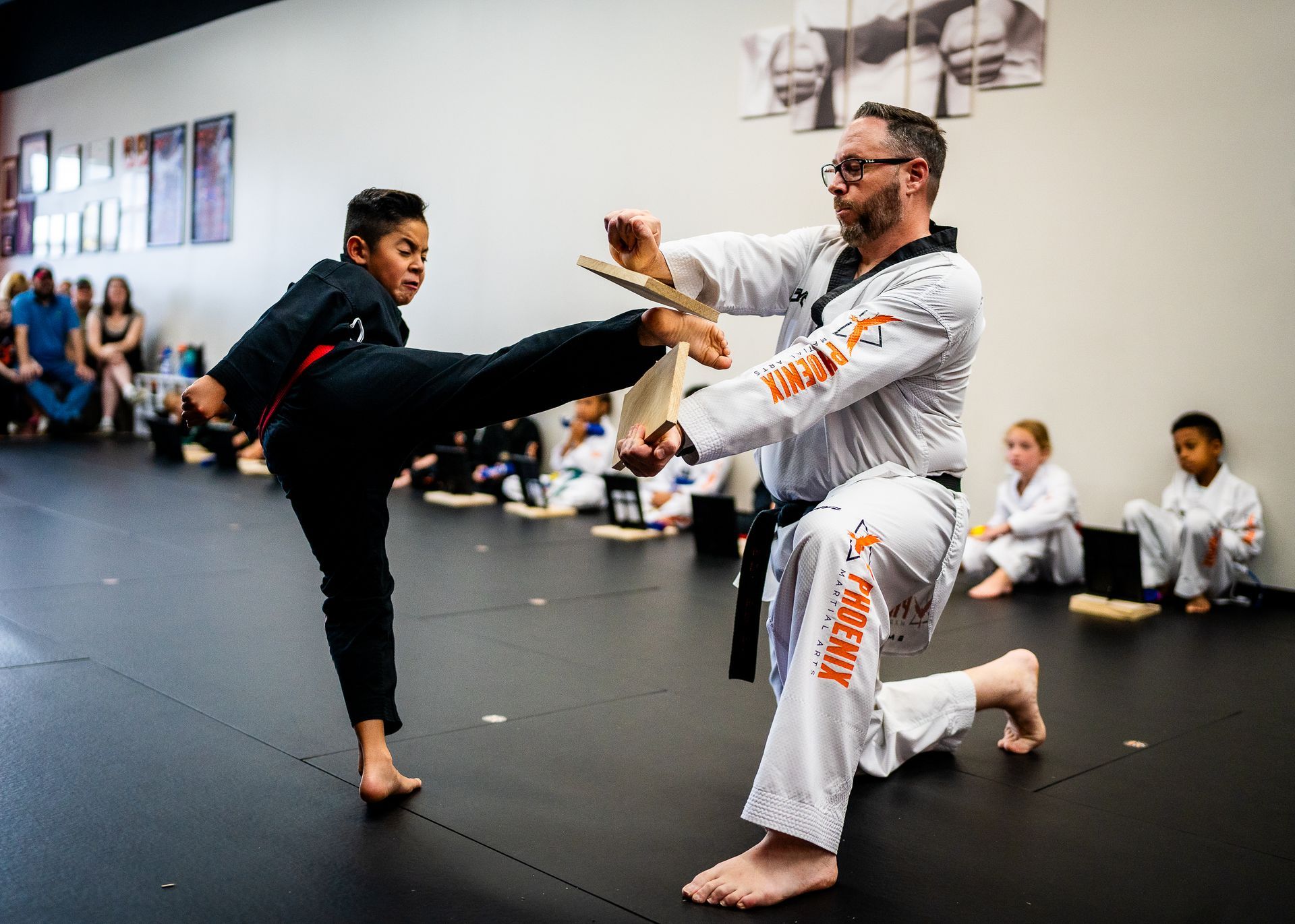 Student breaking boards to build confidence and focus at Phoenix Martial Arts in Murfreesboro, TN