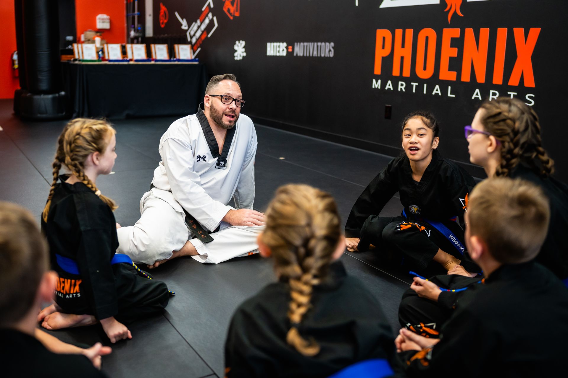 Instructor leading a mat chat to teach leadership, respect, and character at Phoenix Martial Arts in Murfreesboro, TN