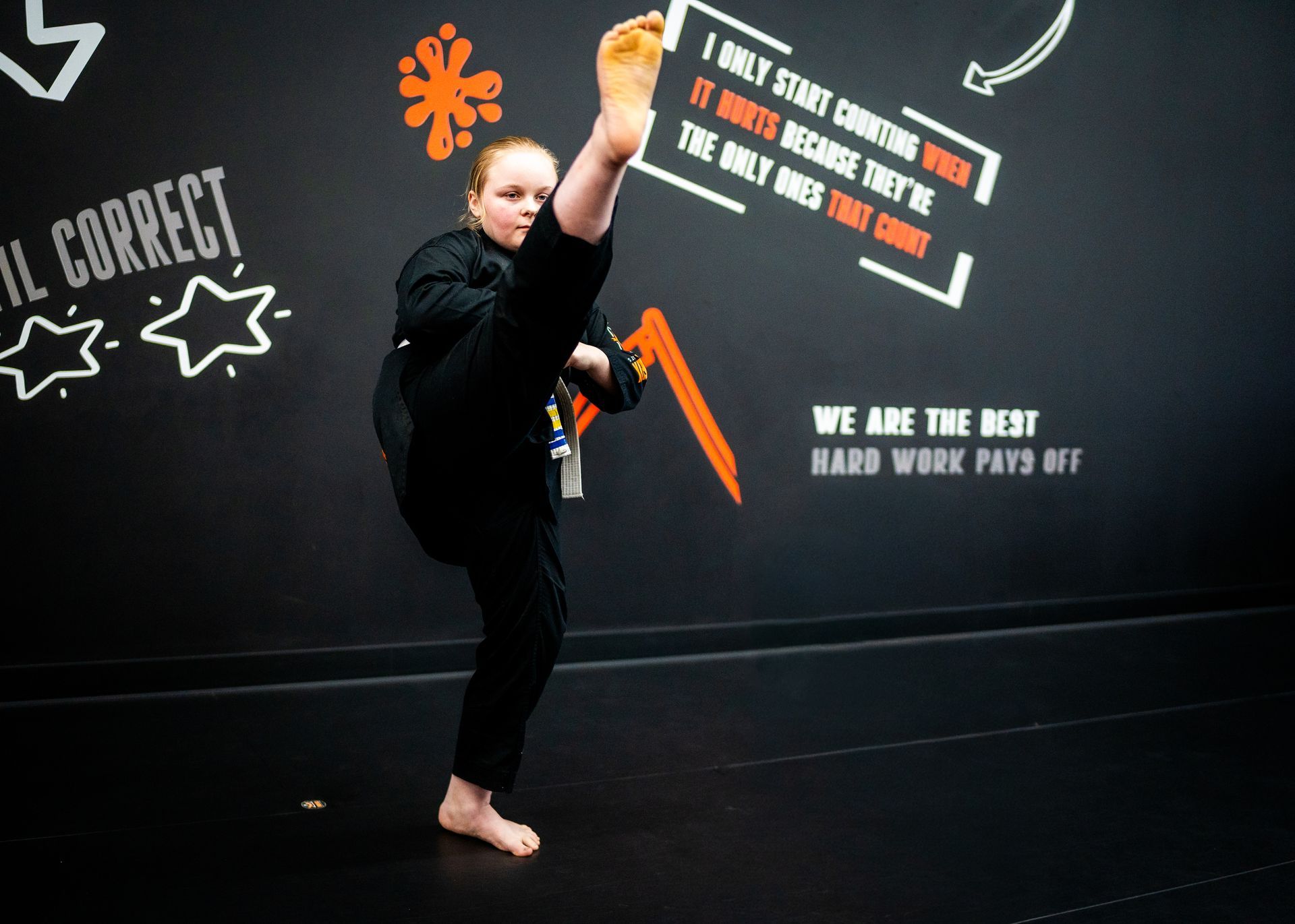 Teen student demonstrating flexibility and control with a high kick at Phoenix Martial Arts in Murfreesboro, TN