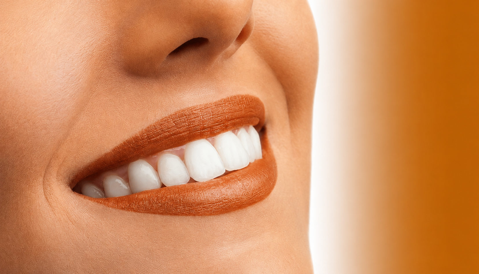 Close-up of a smiling woman with white teeth and pink lipstick.