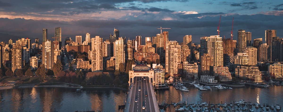 An aerial view of a city skyline at night with a bridge in the foreground.