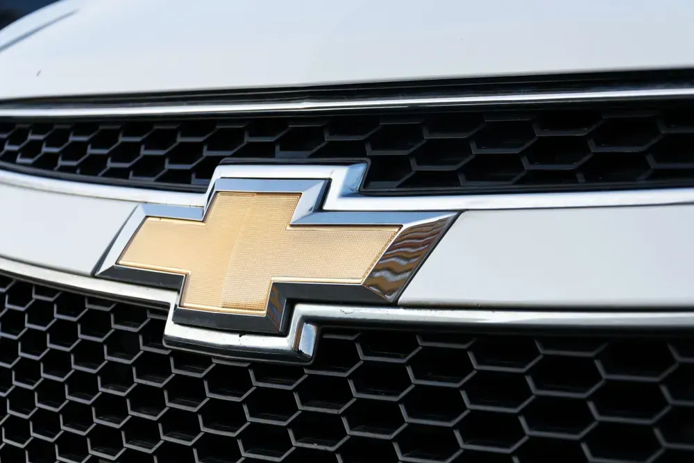 Close-up of a gold Chevrolet bowtie emblem on a black honeycomb grille