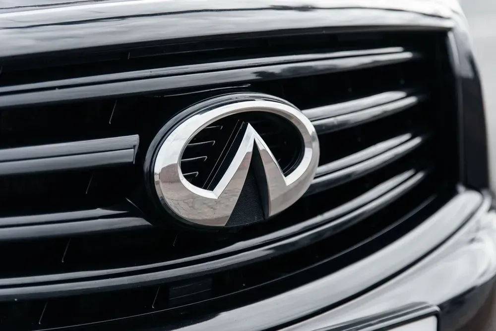 Close-up of an Infiniti car grille and chrome emblem on a black front end