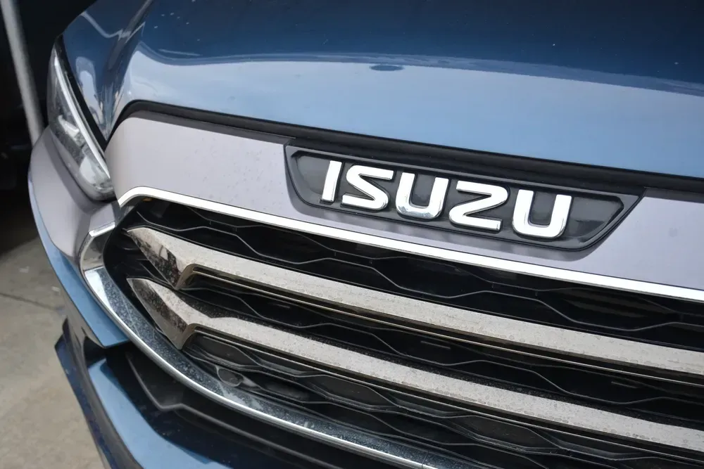 Close-up of a blue Isuzu truck front grille and emblem