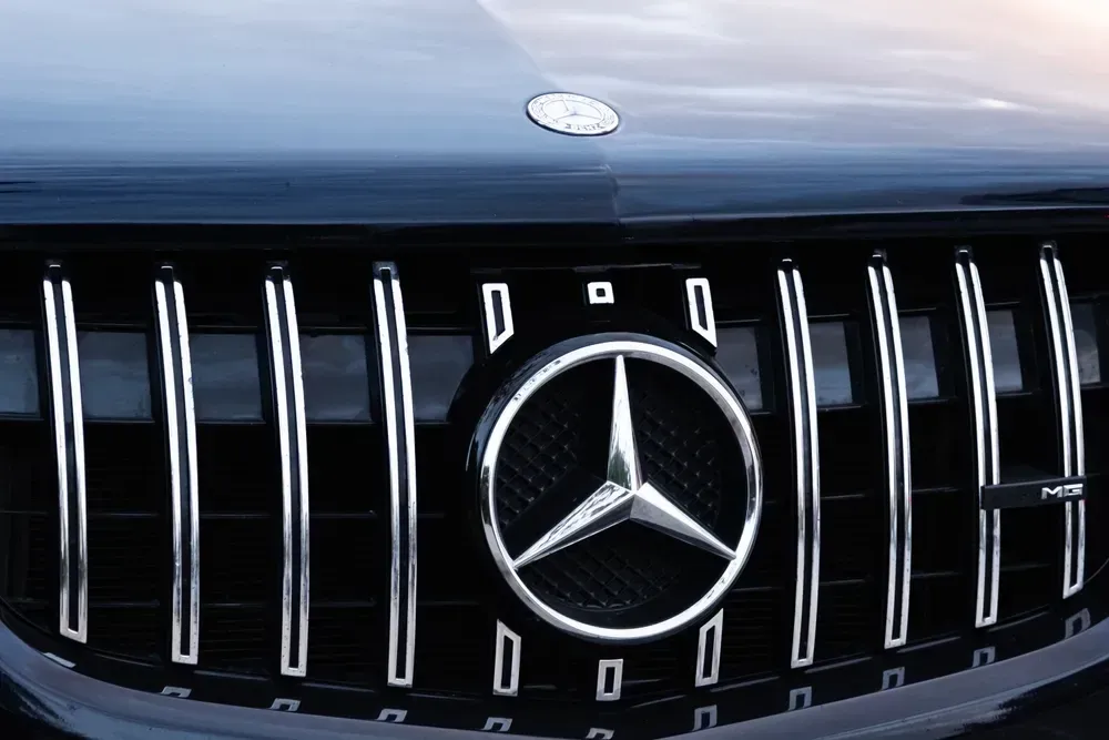 Close-up of a black Mercedes-Benz grille with chrome vertical slats and silver star emblem