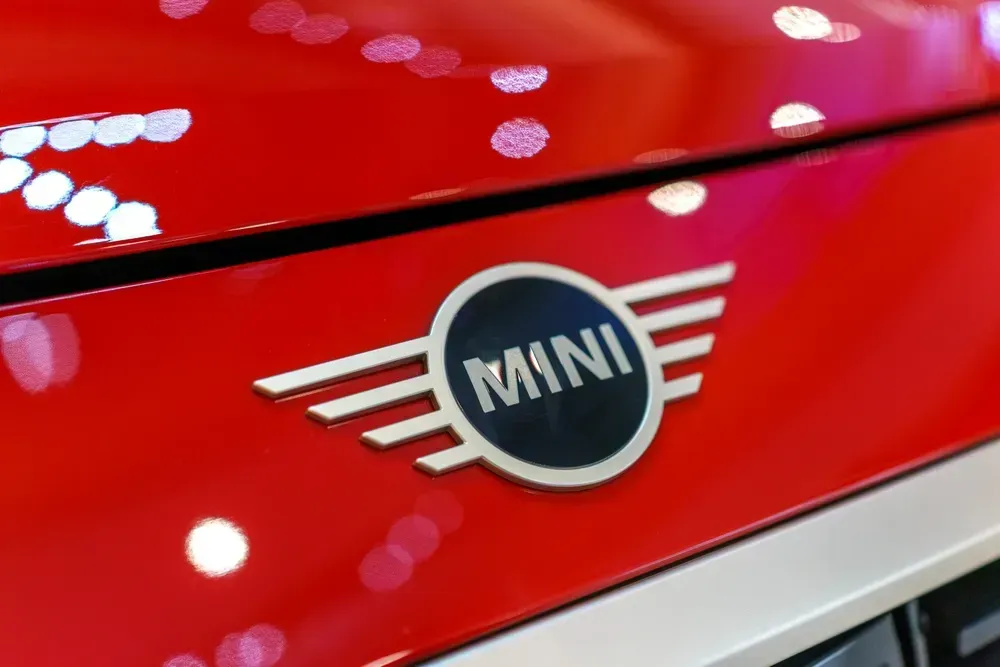 Close-up of a red MINI car hood with the winged MINI logo