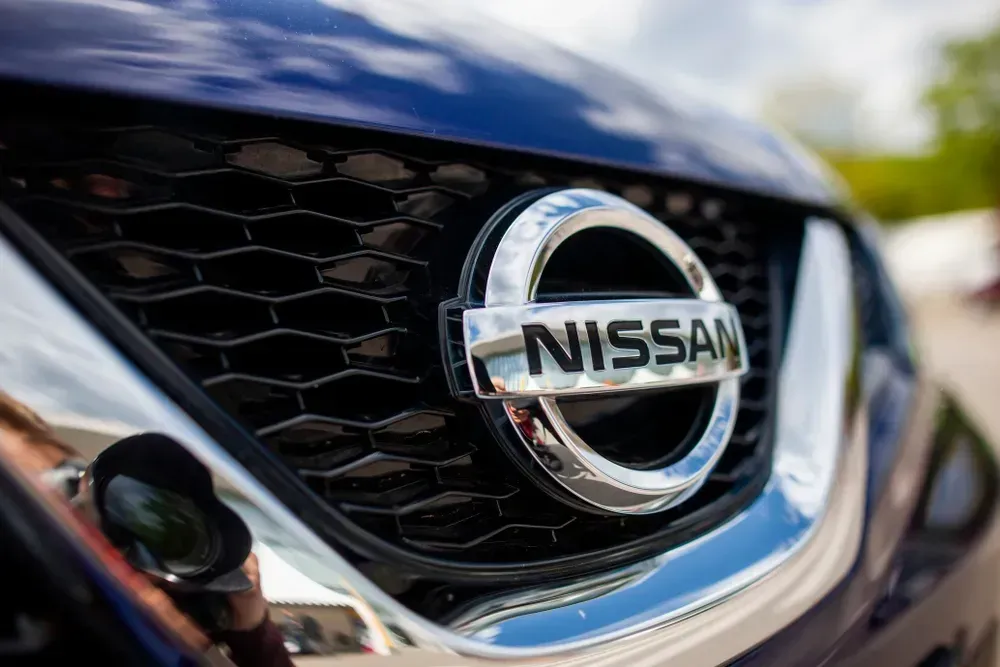 Close-up of a Nissan car grille with chrome emblem and black mesh detail