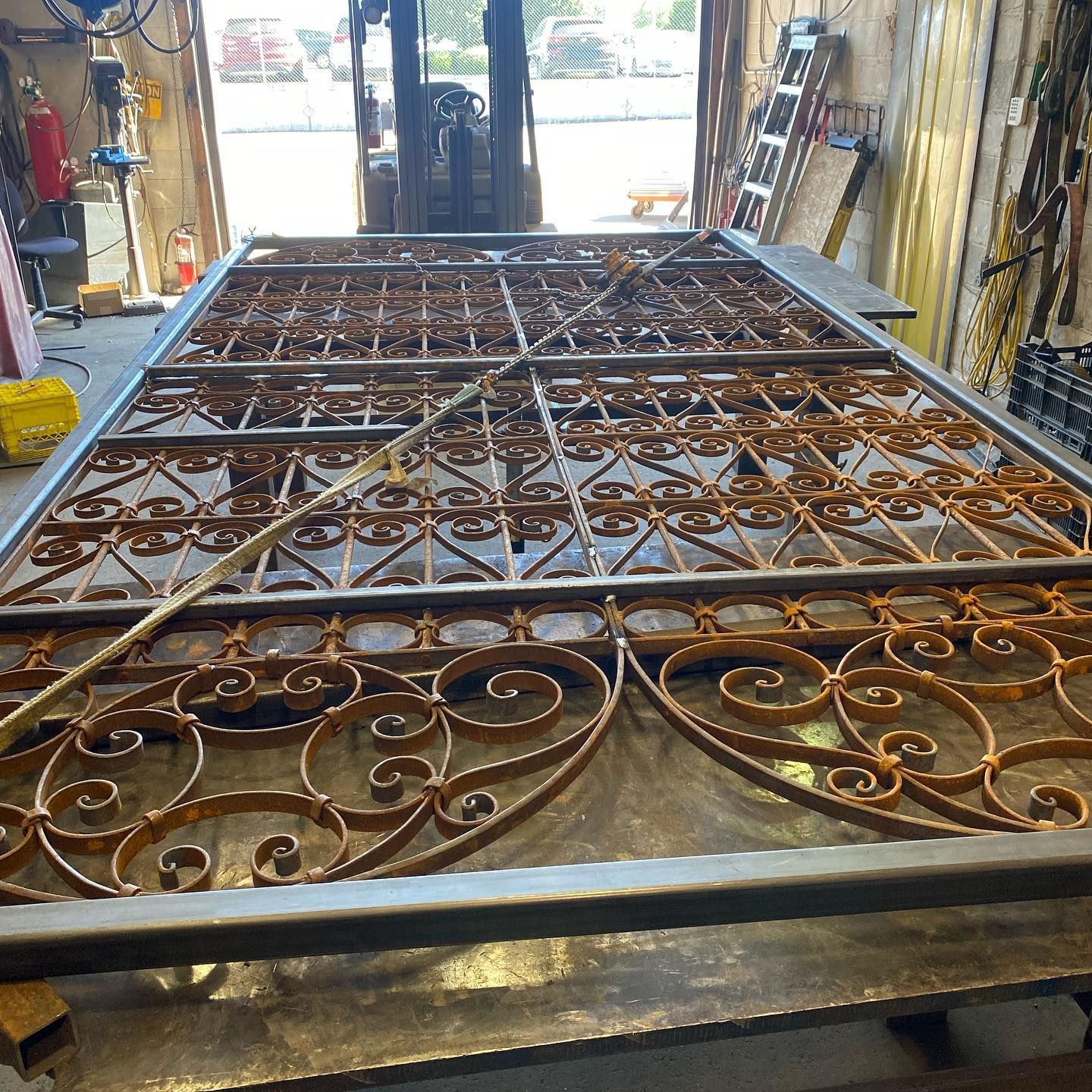 A wrought iron gate is sitting on a table in a workshop.