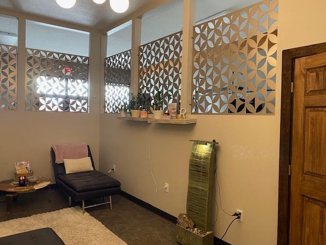 Spa-like room with lounge chair, decorative wall panels, and a tall heater on the floor