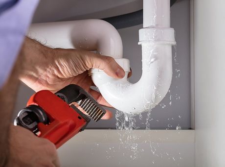 Plumber Fixing Sink Pipe With Wrench — Santa Clarita, CA — Larsen Plumbing Plumber Fixing Sink Pipe With Wrench — Santa Clarita, CA — Larsen Plumbing