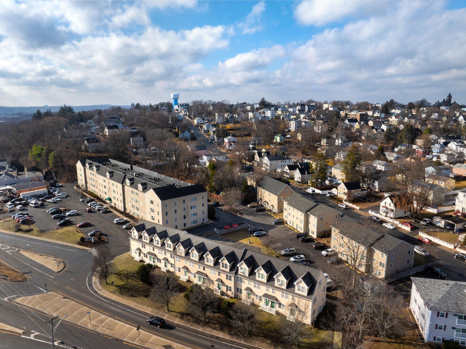 Aerial view of apartment buildings and a residential neighborhood under a cloudy sky